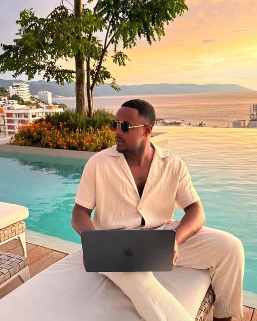 Hassan working on his laptop by the pool
