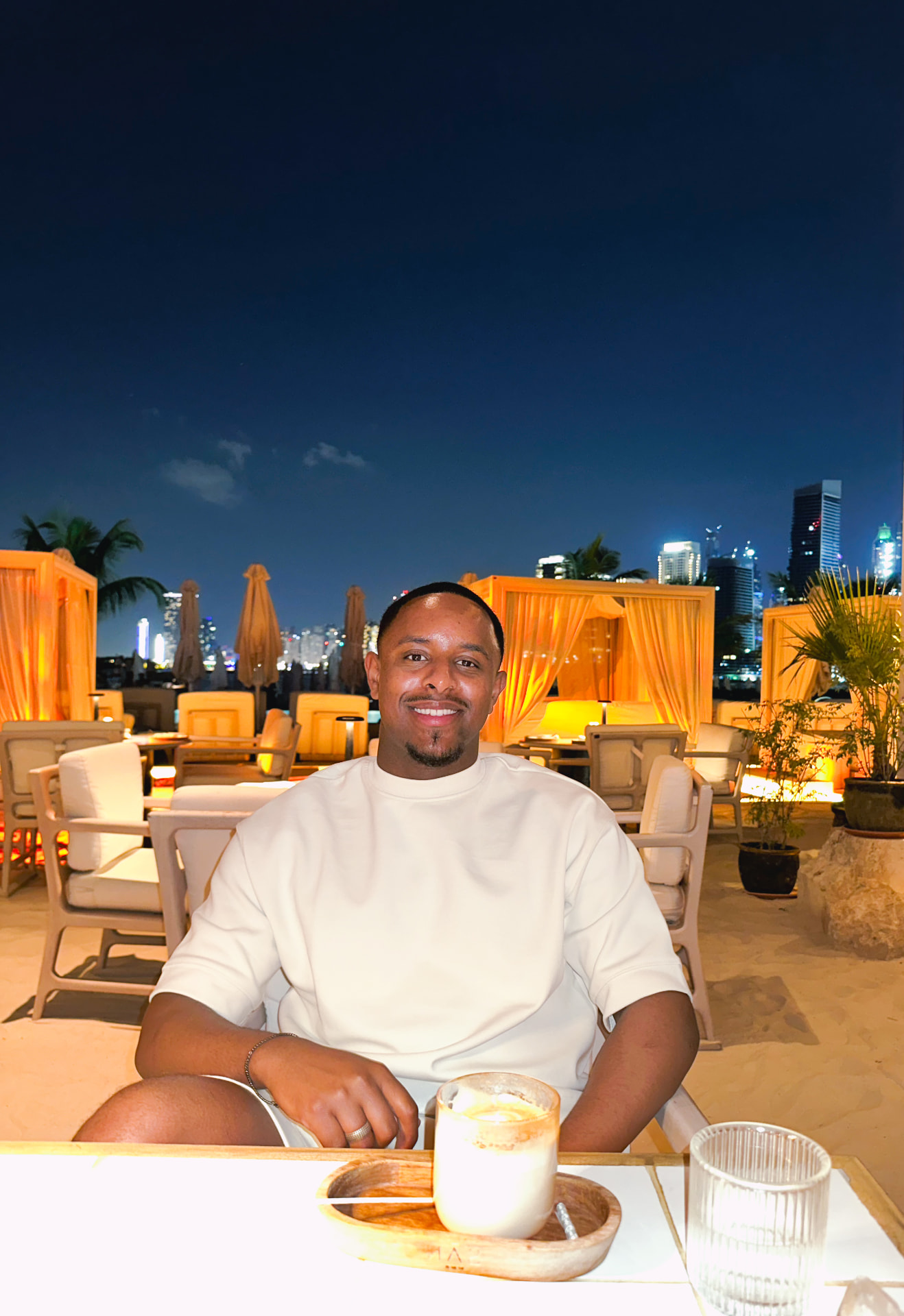 Hassan at a rooftop lounge at night